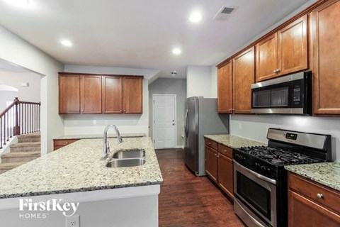 A kitchen with wooden cabinets and a granite countertop.