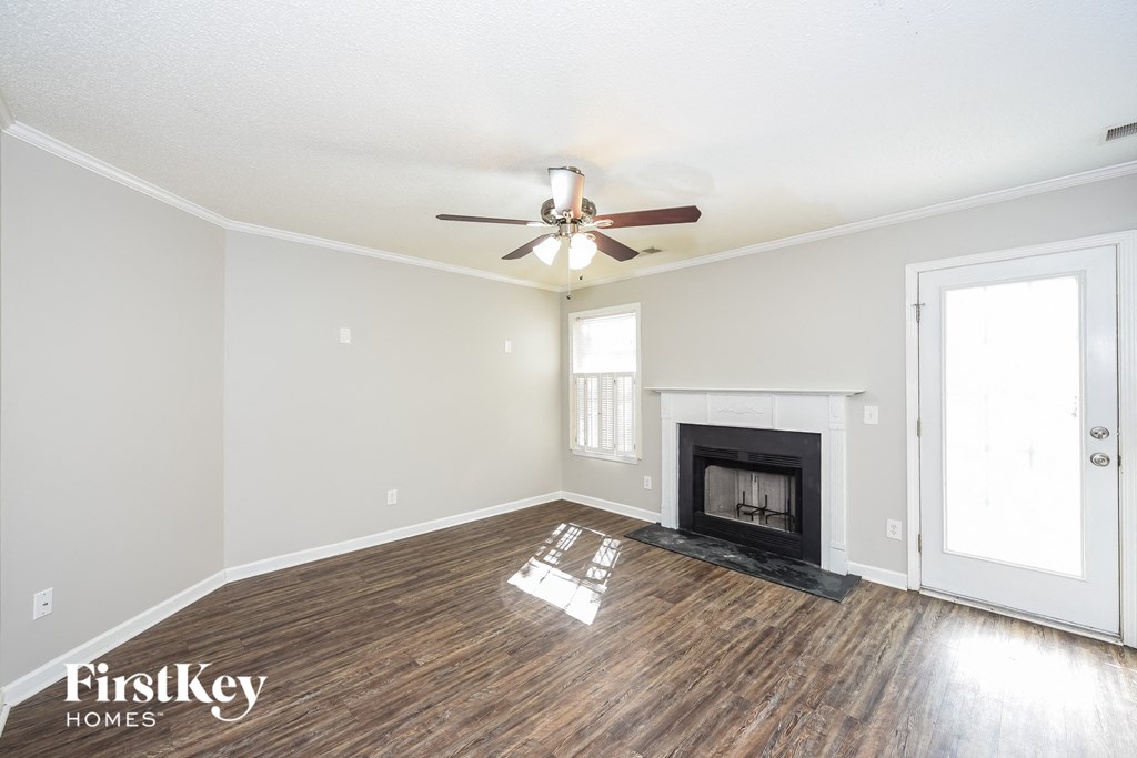 a living room with a fireplace and a ceiling fan