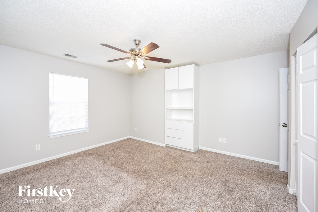 a bedroom with carpet and a ceiling fan