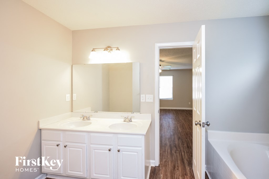 a bathroom with white cabinets and a sink and a mirror