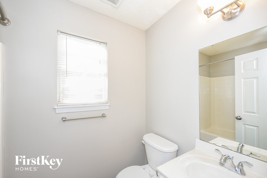 a bathroom with a sink toilet and a mirror