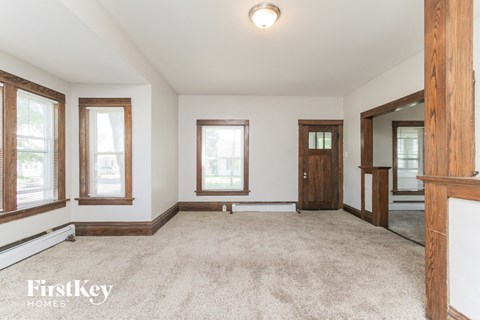 an empty living room with white walls and wooden doors and windows
