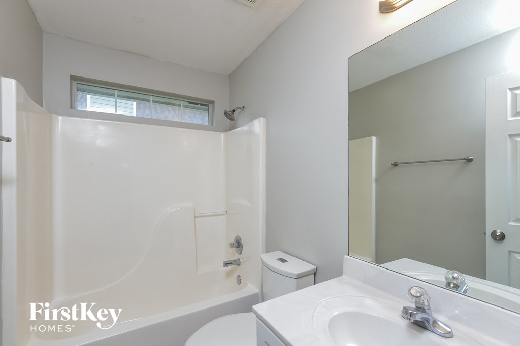 A white bathroom with a toilet, sink, and tub.