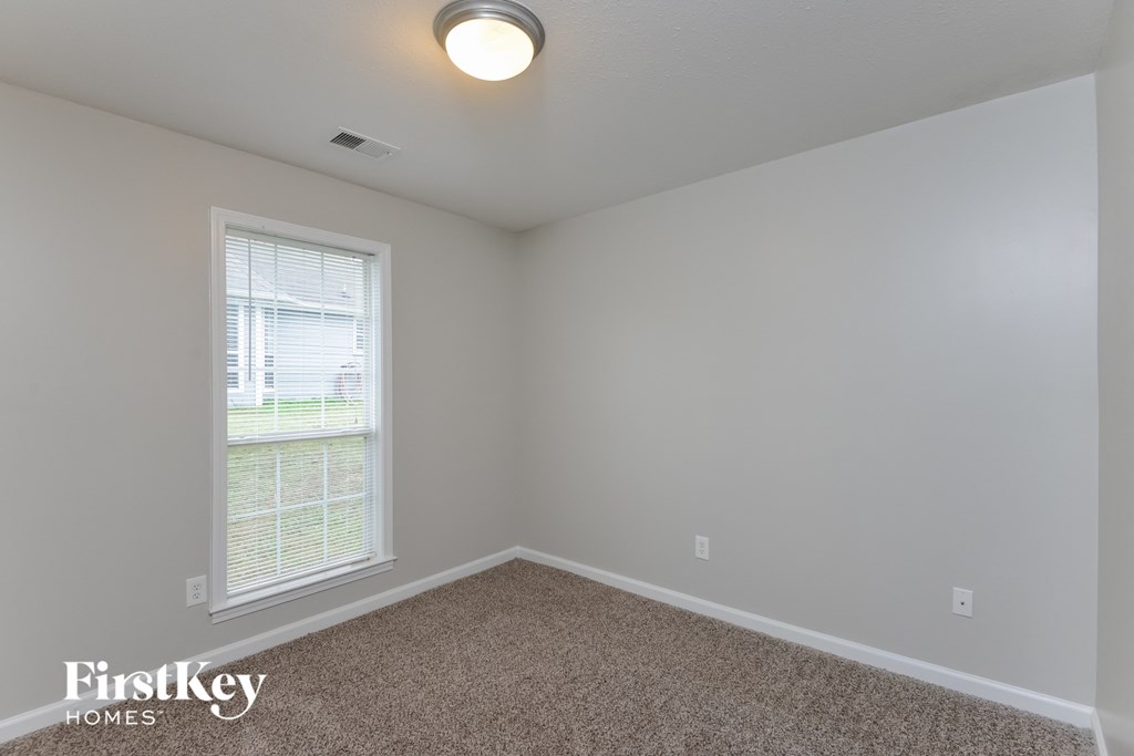 A room with a carpeted floor and a window.