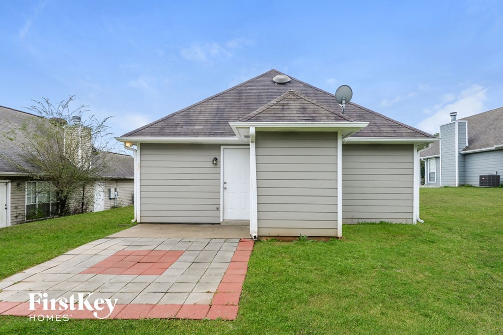 A house with a grey siding and a brown roof is for sale.