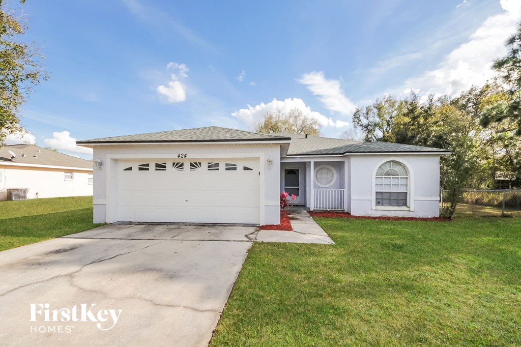 a white house with a driveway and a lawn