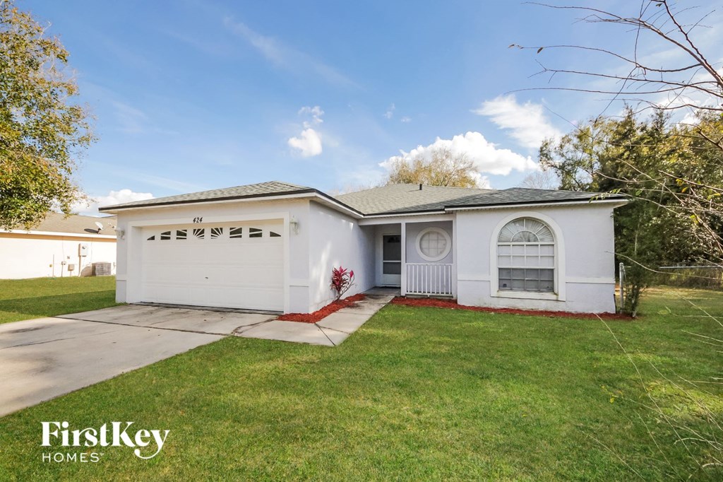 a white house with a lawn and a driveway