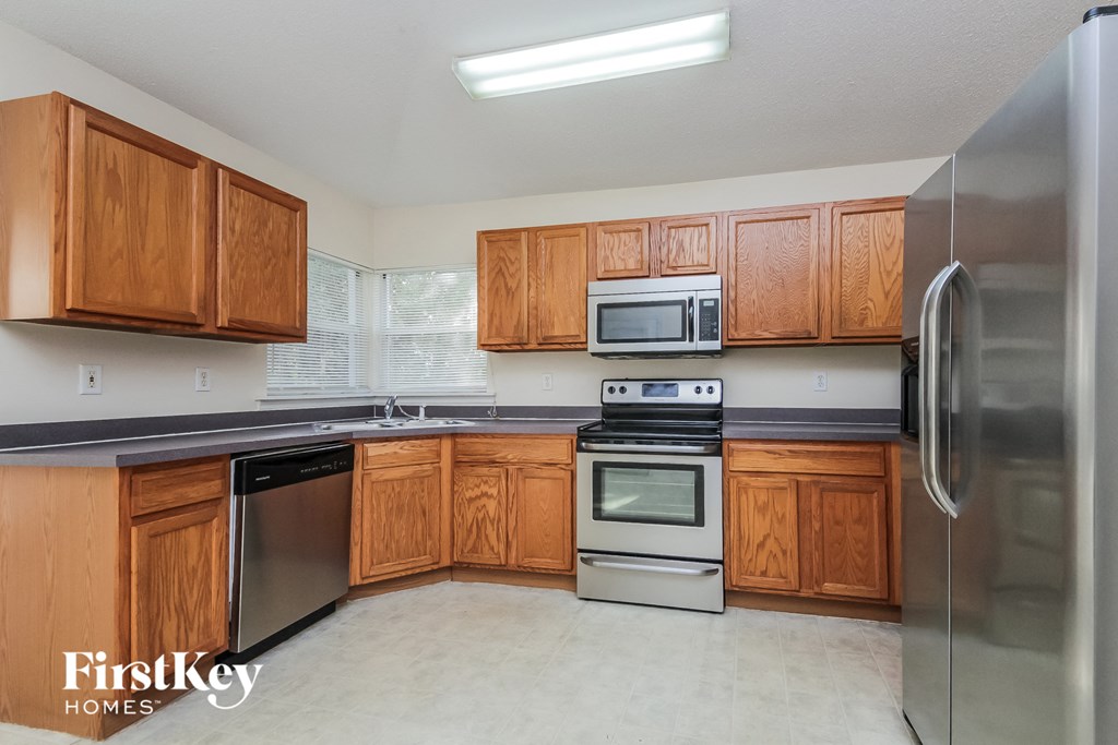a kitchen with wooden cabinets and stainless steel appliances