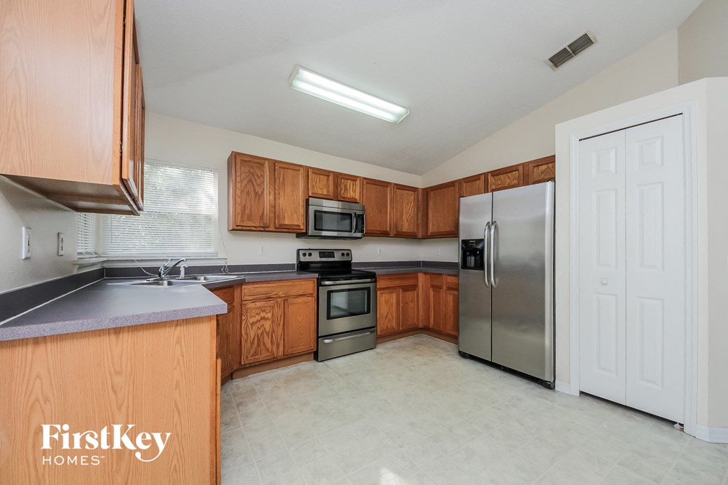 a kitchen with wooden cabinets and stainless steel appliances