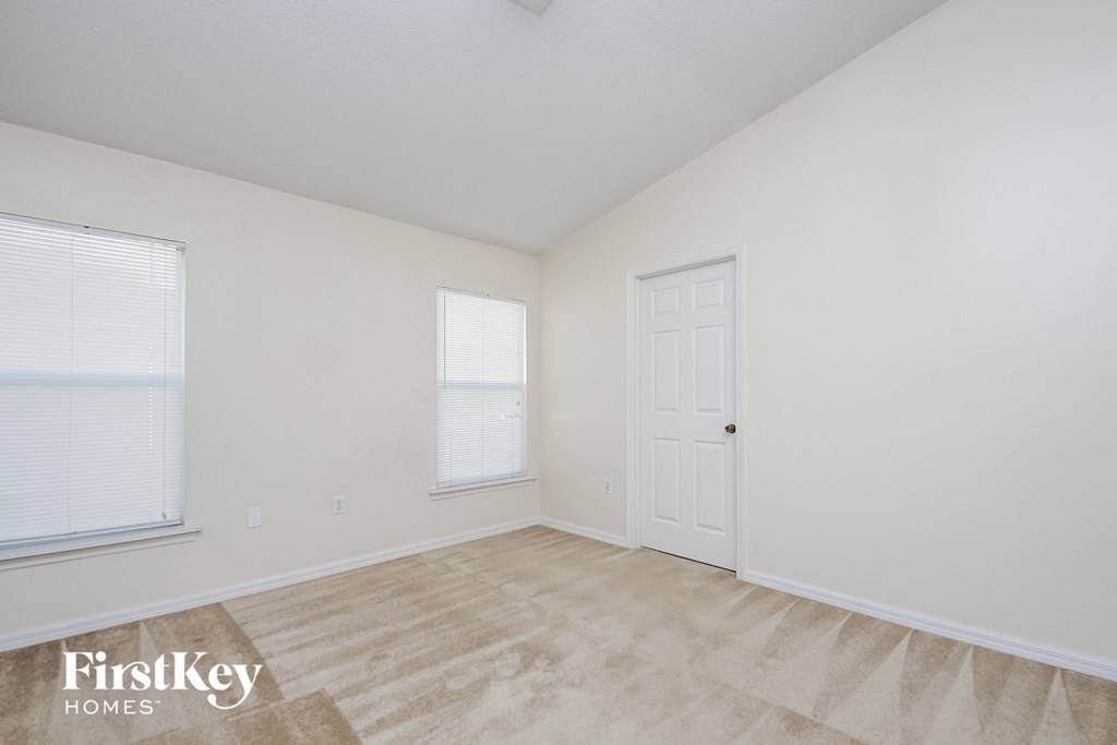 a spacious living room with white walls and a white door
