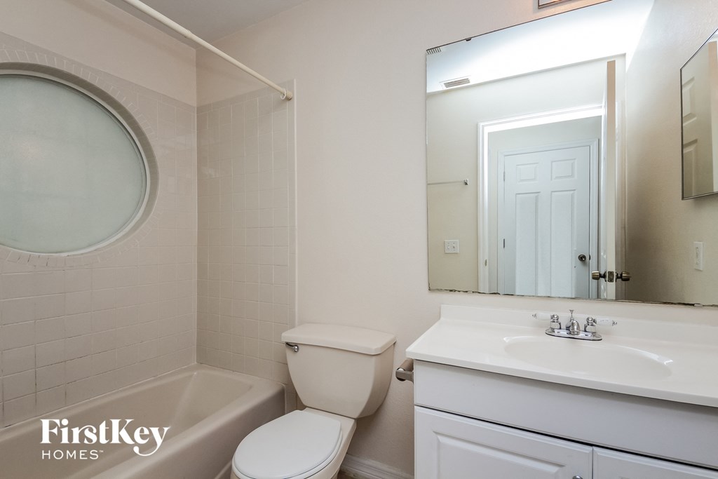 a bathroom with a sink toilet and a mirror