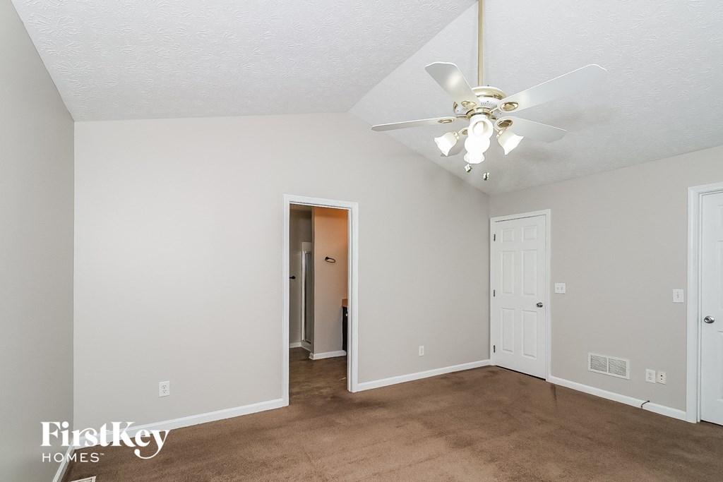 a living room with a ceiling fan and a door to a closet