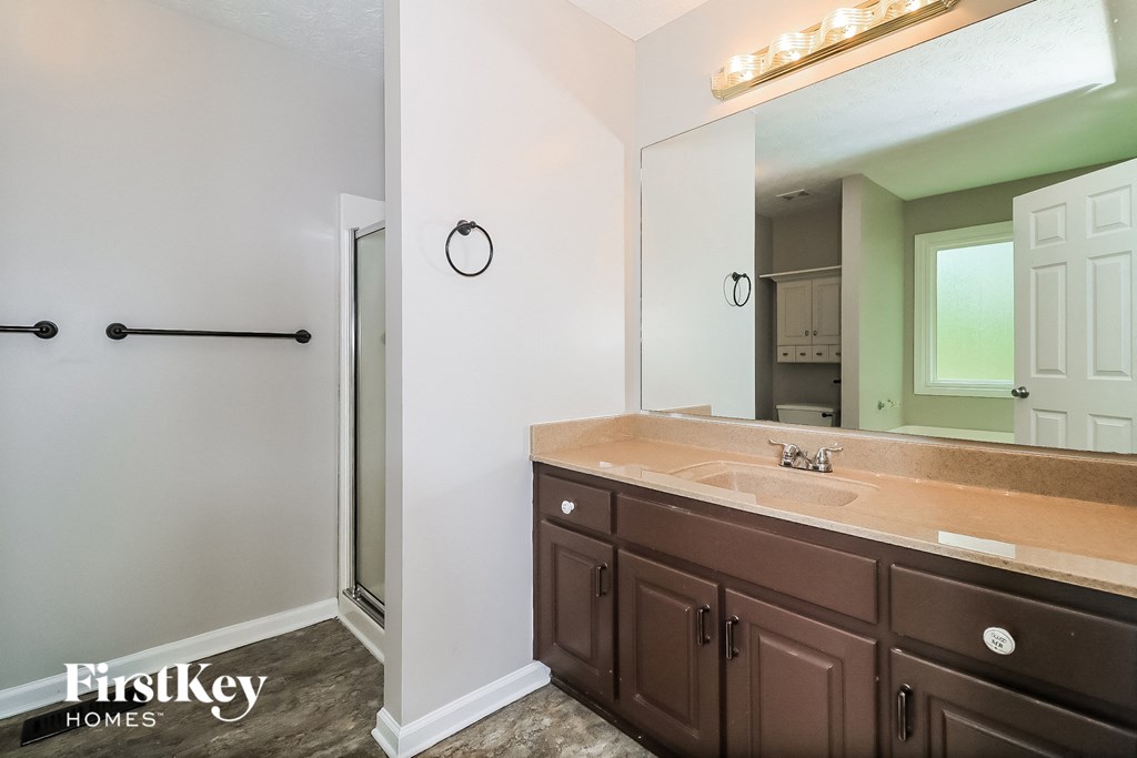the master bathroom has a large mirror and a double sink