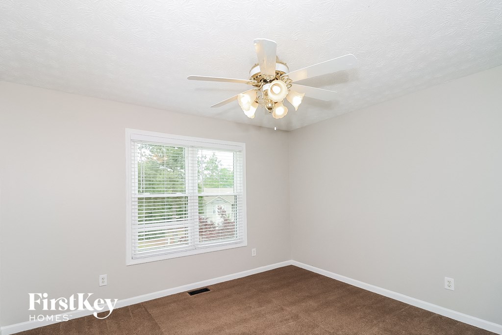 a bedroom with a ceiling fan and a window