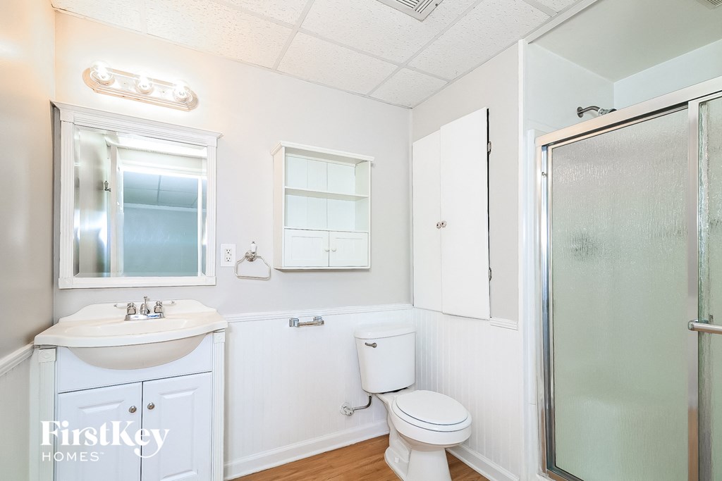 a white bathroom with a shower toilet and sink