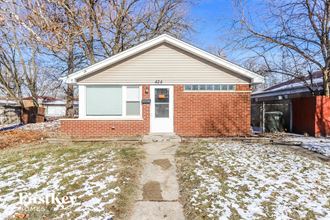 a brick home with a white front door and snow on the ground