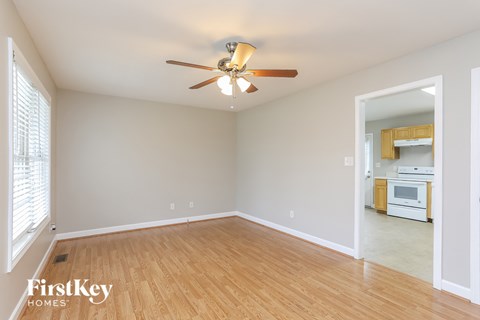 a living room with wood flooring and a ceiling fan