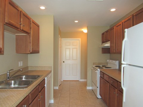 a kitchen with wooden cabinets and a white refrigerator