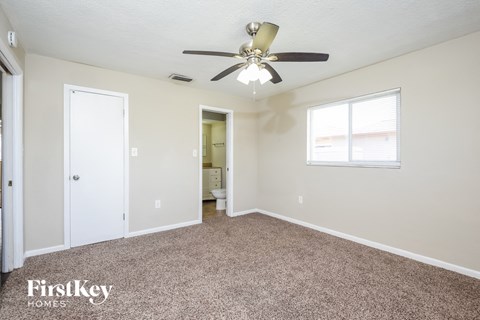 a living room with carpet and a ceiling fan