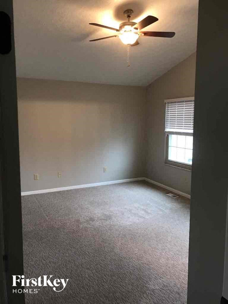 an empty living room with a ceiling fan