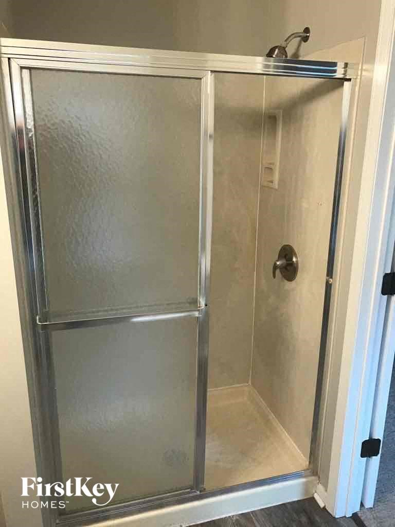 a small shower with a glass door in a bathroom