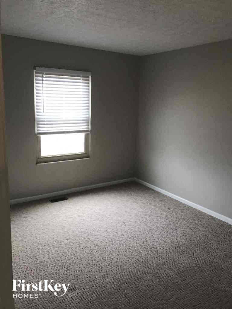 an empty room with a window and a carpet