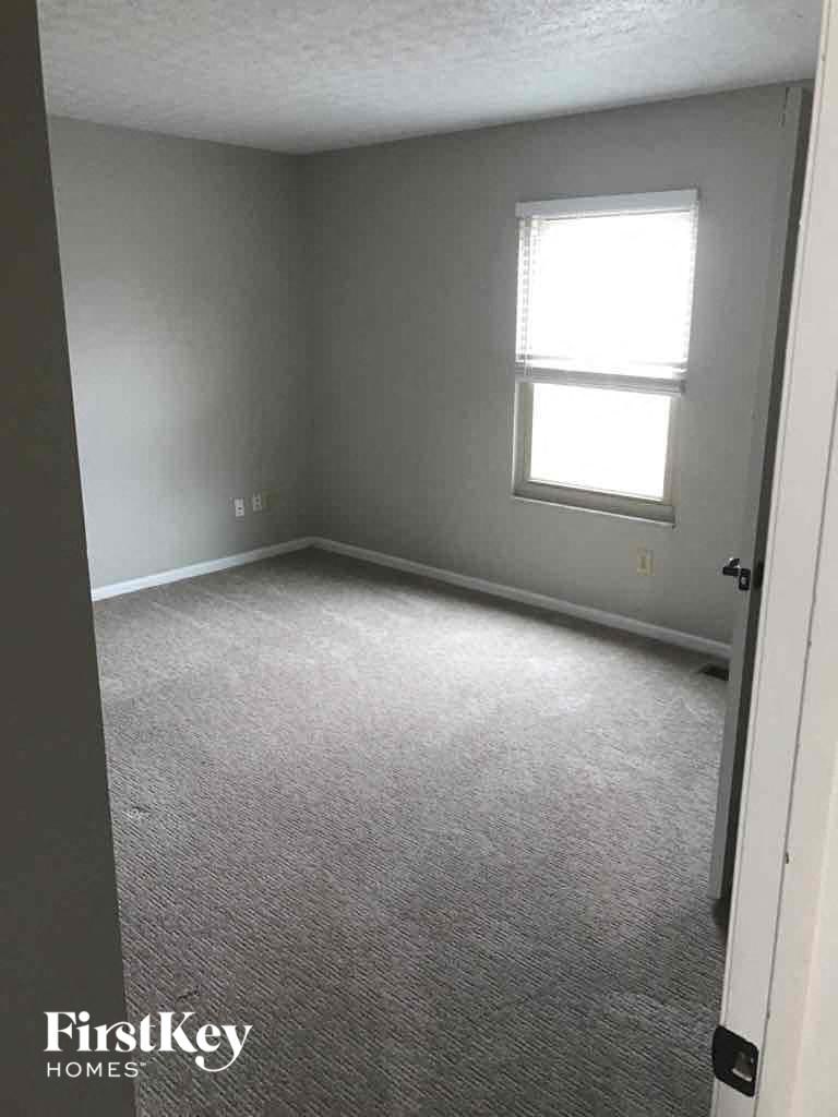 an empty room with a window and a carpeted floor