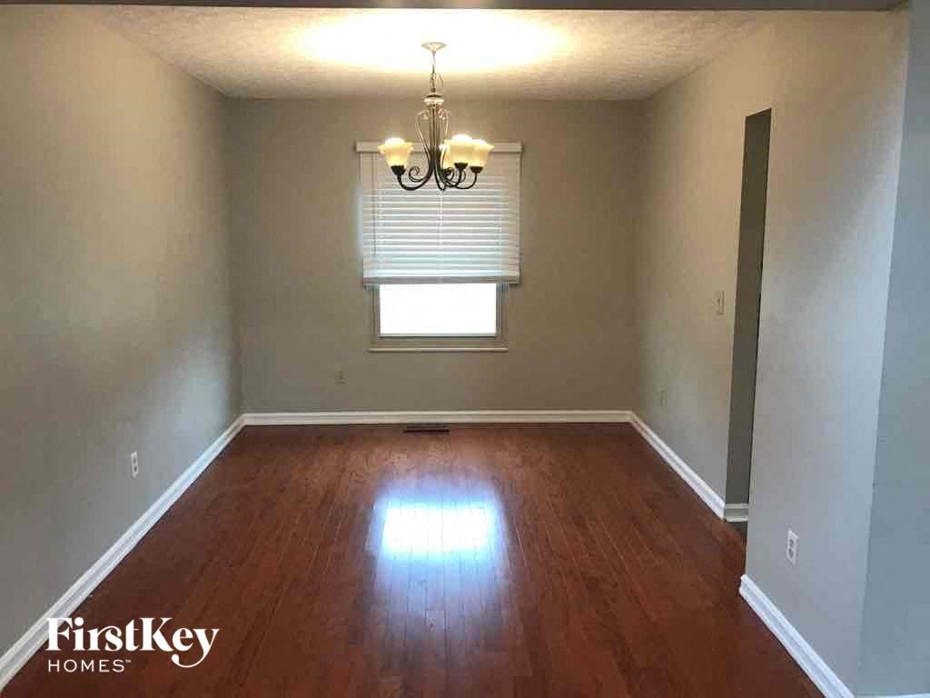 an empty living room with wooden floors and a window