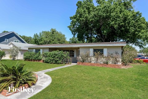 a house with a lawn and a sidewalk in front of it