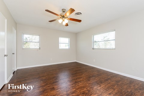 a living room with wood floors and a ceiling fan