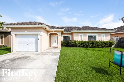 A house with a white garage door is for sale by FirstKey Homes.
