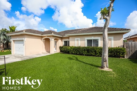 A house with a tree in front of it is for sale with FirstKey Homes.