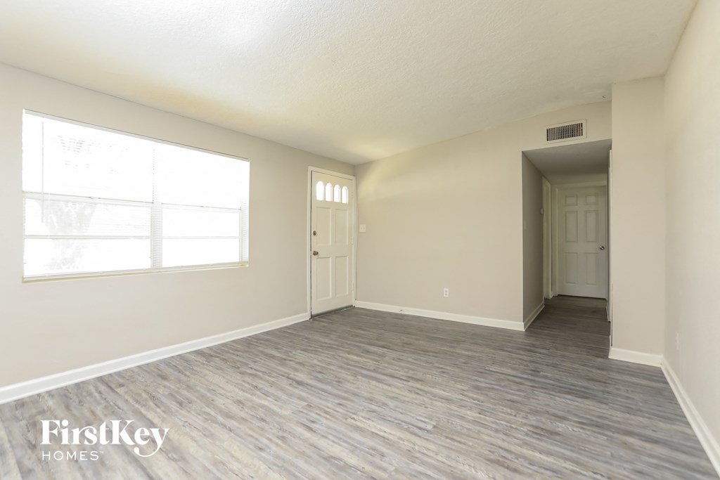 the living room of an empty house with a large window