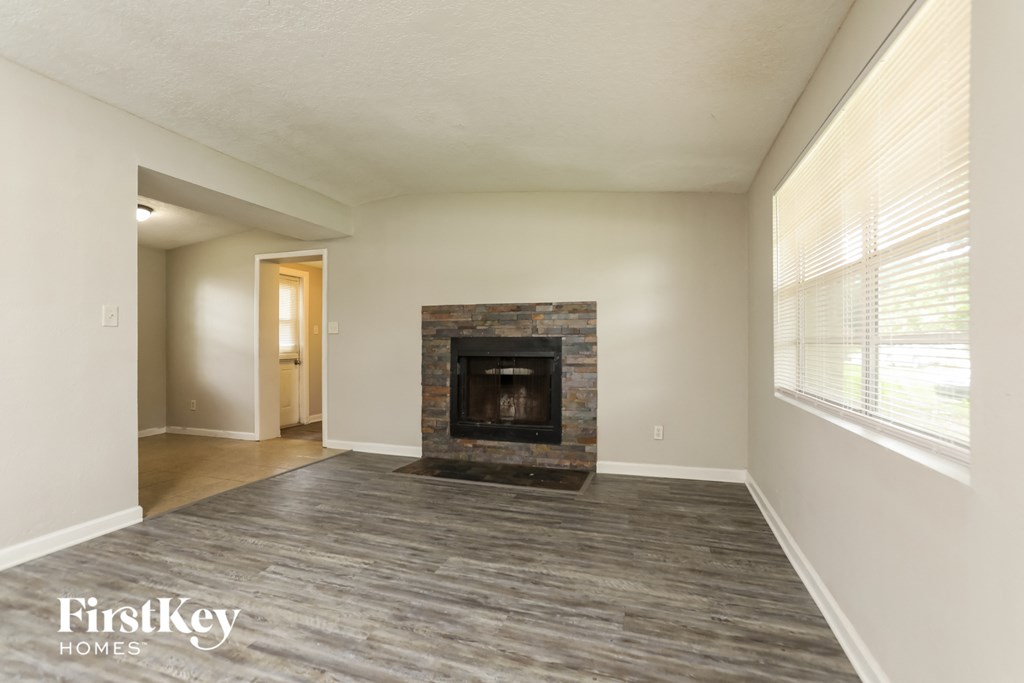 a living room with a fireplace and a large window