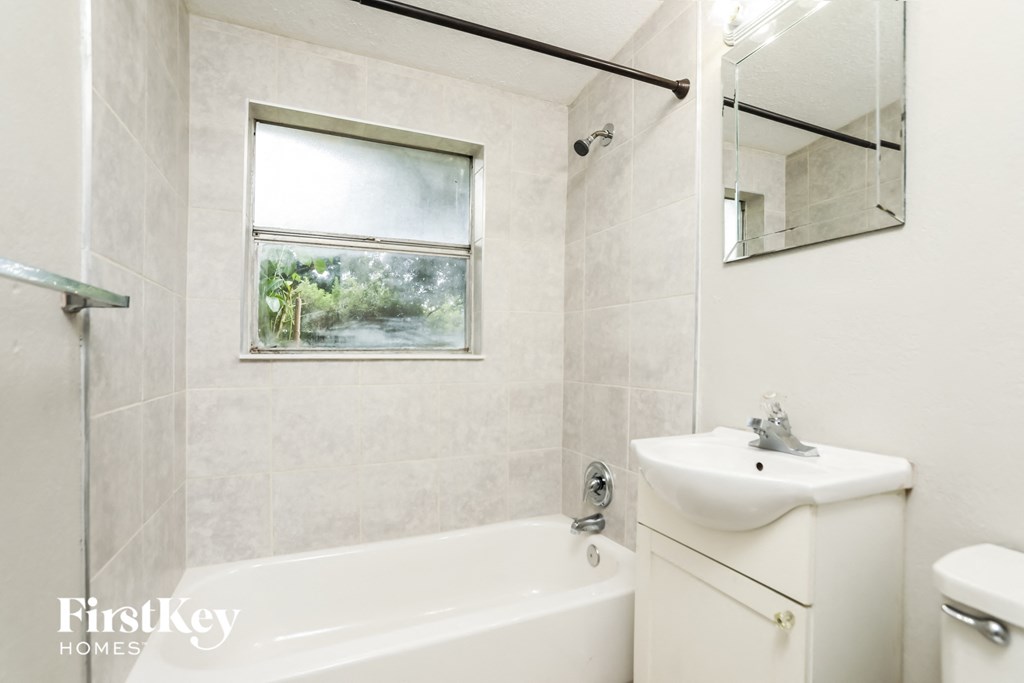a bathroom with a tub and a sink and a mirror
