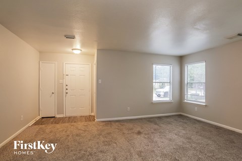 A bedroom with a carpeted floor and two doors.
