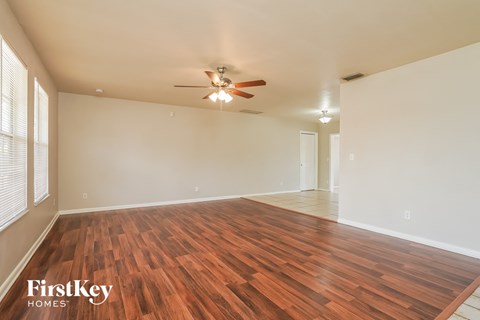 a living room with wood flooring and a ceiling fan