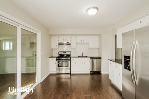 A kitchen with white cabinets and stainless steel appliances.