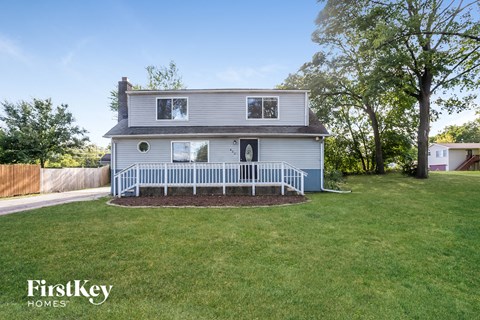 a white house with a yard and a white fence