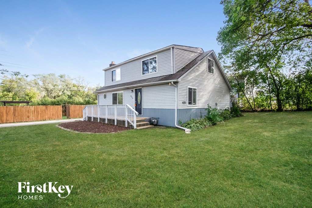 a white house with a yard and a white fence