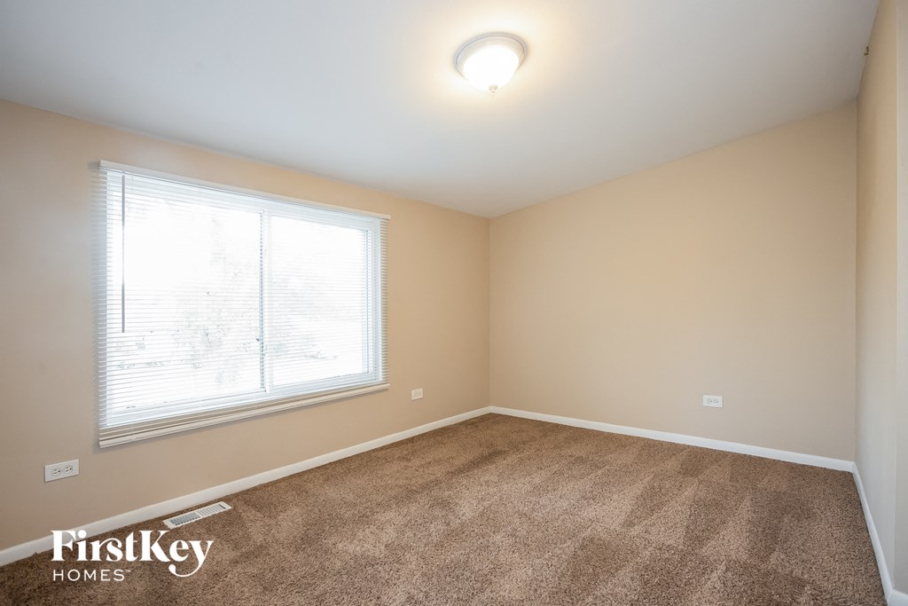an empty room with carpet and a window