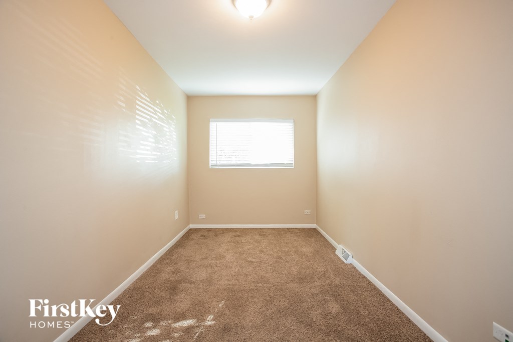 a empty room with carpet and a window