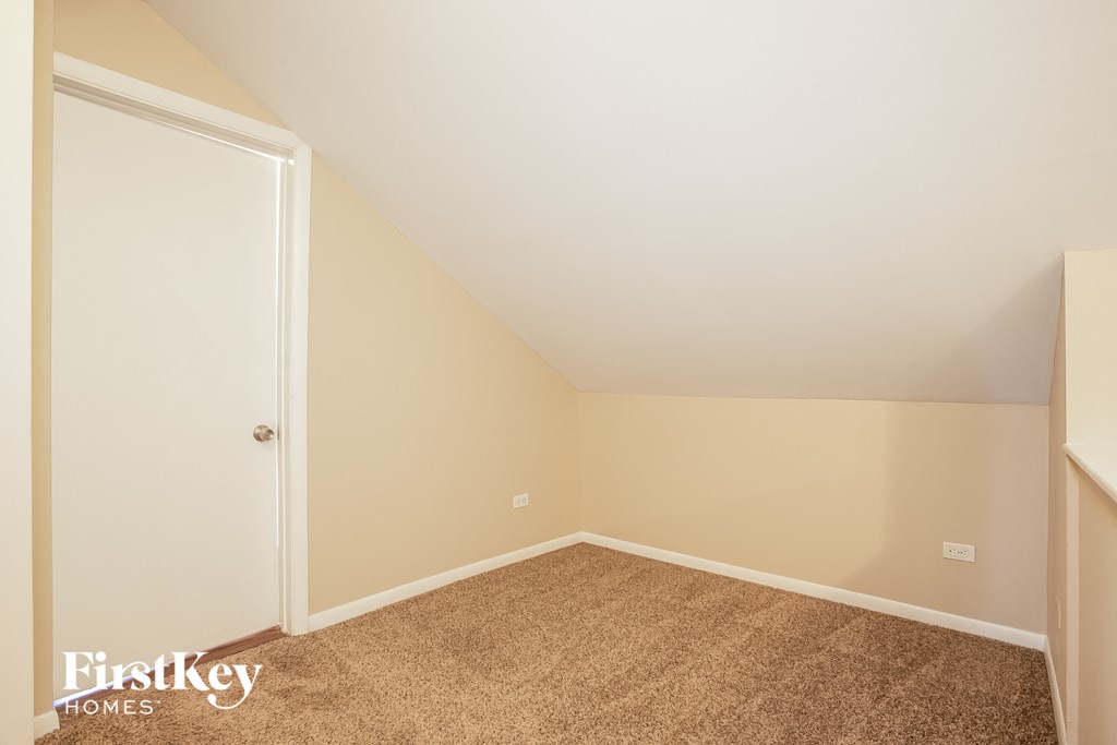 a bedroom with a carpeted floor and a door to a closet