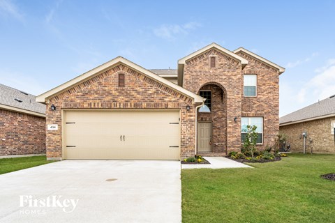 house with a garage door in front of a lawn