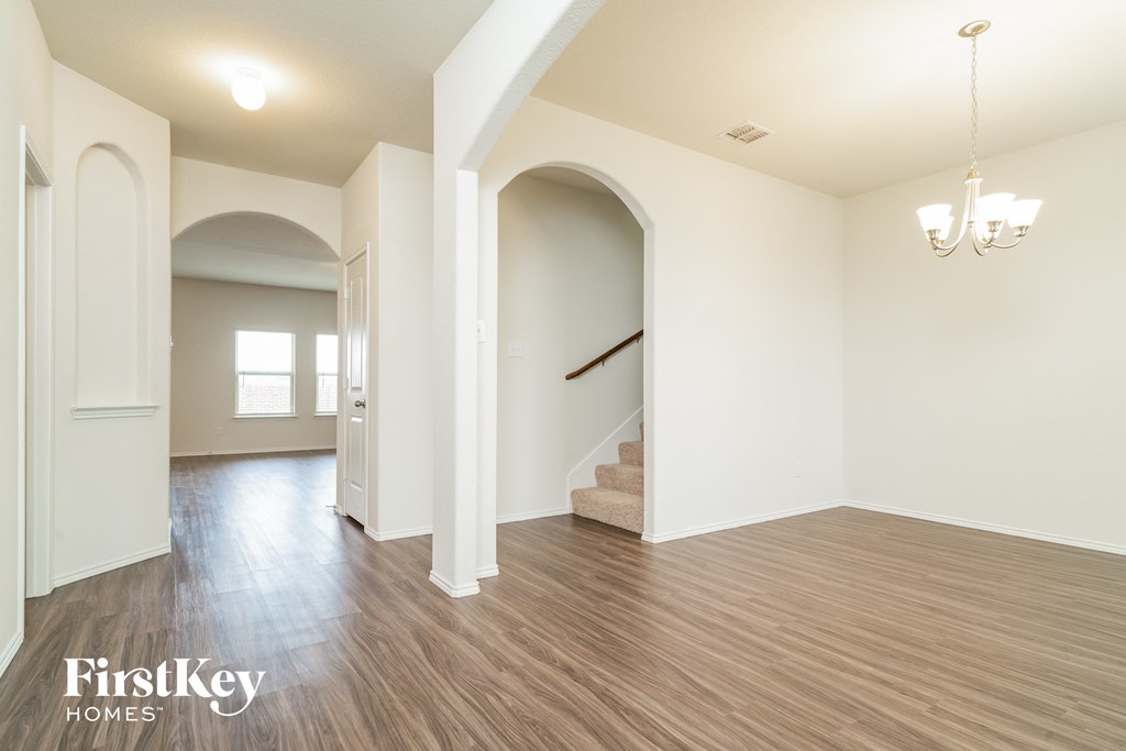 an empty living room with white walls and wood floors