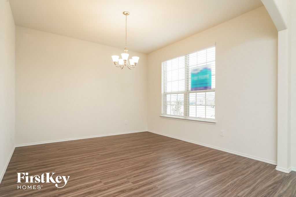 the spacious living room with wood flooring and a window