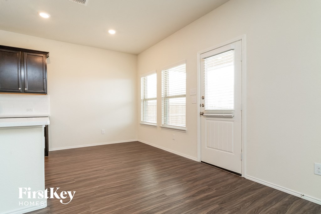 a living room with a door and a kitchen