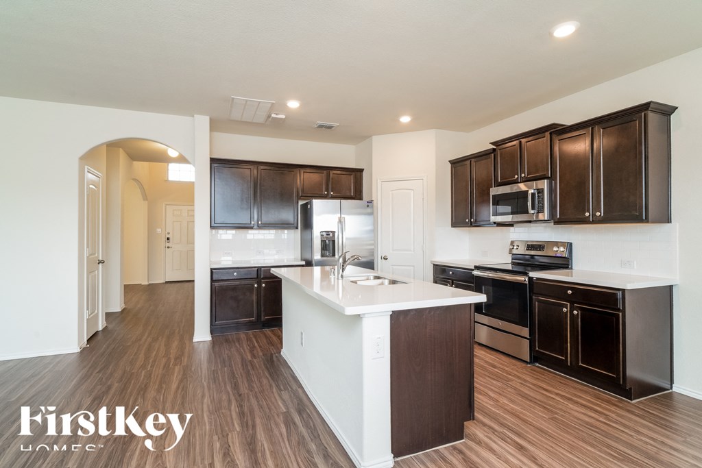 a kitchen with dark wood cabinets and a white counter top
