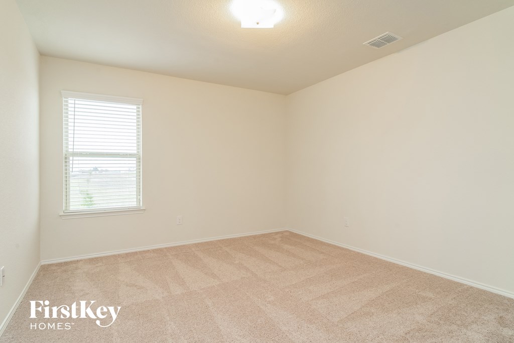 a bedroom with a carpeted floor and a window