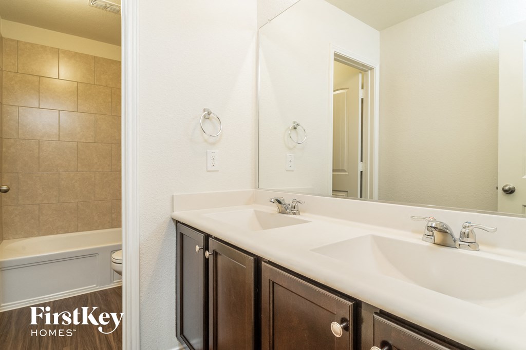 a bathroom with two sinks and a shower and a mirror